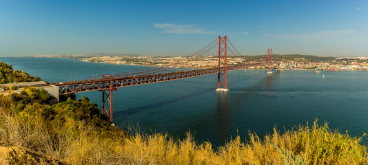 Lisbon, Portugal and the suspension bridge over the Tagus river viewed from the Almada district