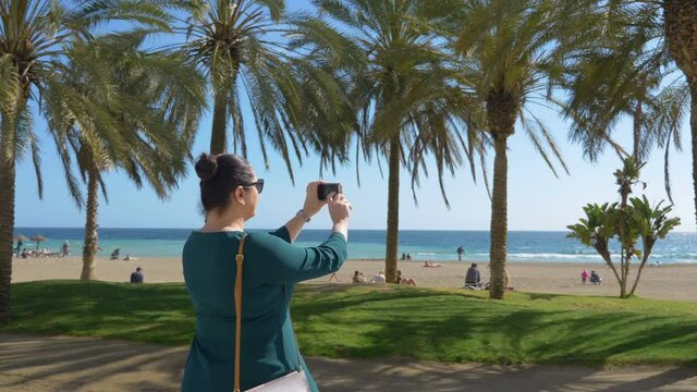 Woman taking picture of seaside in Malaga in Spain in 4k slow motion 60fps