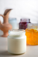 Homemade yogurt with orange marmalade glass jar. Healthy dairy probiotic breakfast.