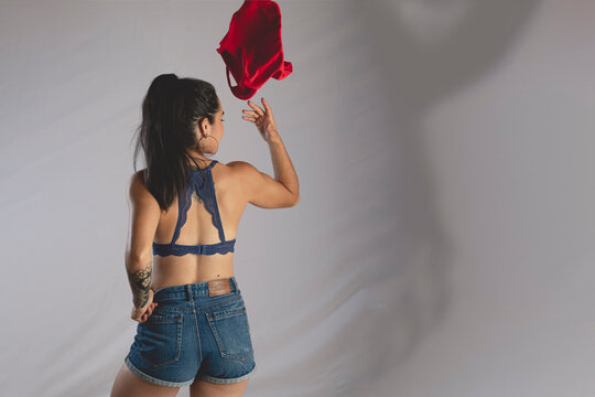 Mujer joven de espaldas quit&aacute;ndose la ropa