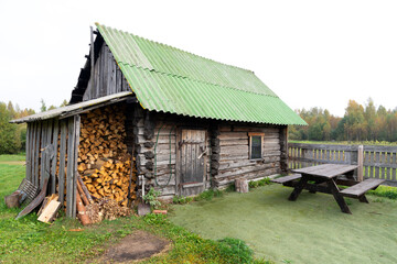Old wooden house. Place for laying wood for kindling the stove near the house