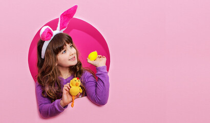 Obraz na płótnie Canvas Funny happy child girl with Easter eggs and bunny ears