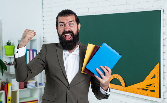 great day. learning the subject. happy man with beard holding book. literature for studying. informal education. male student in school classroom while lesson. pass the exam