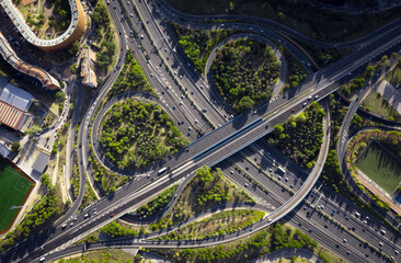 Naklejka premium top view of roundabout road with cars and little traffic many roads with bridges trees nature and sky with sky light