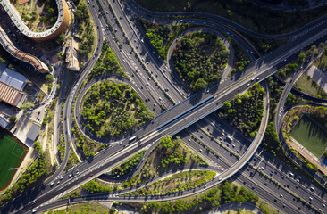 
top view of roundabout road with cars and little traffic many roads with bridges trees nature and sky with sky light
