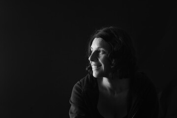 side view of a portrait of a woman on black background
