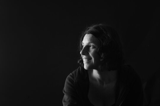 side view of a portrait of a woman on black background
