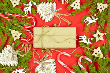 Christmas composition. Gifts, spruce branches, christmas decorations and toys on red background