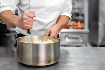 Fototapeta na wymiar Unrecognizable Chef stirring in a pot in. High quality photo