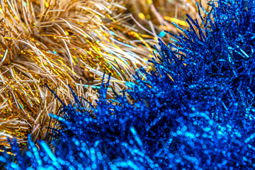 christmas festive background of golden and blue foil tinsel texture close up