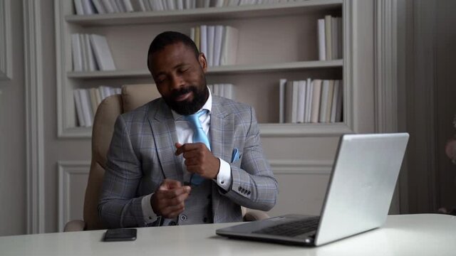 happy businessman is dancing sitting in office, rejoicing by win and successful negotiations with partners