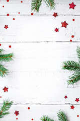 Fir branch and stars on white wooden background with copy space for text. Christmas concept.