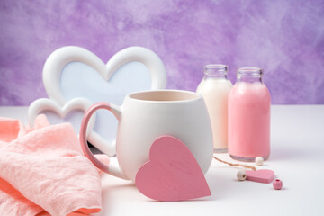 Pink heart on a coffee mug on a romantic background. Side view with space for copying. Holiday background, February 14.