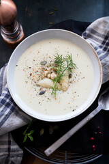 Closeup view of a delicious asparagus soup with a sprig of dill at the top.