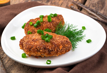 Two juicy meat cutlets close-up on a natural wooden background. Side view. The concept of cooking.