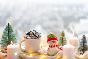 Winter Christmas holidays background with candles; christmas light; Cup of cocoa with marshmallow...