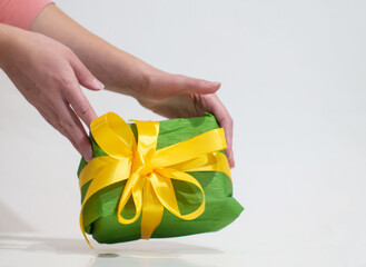 woman giving a green box with yellow bow as a gift