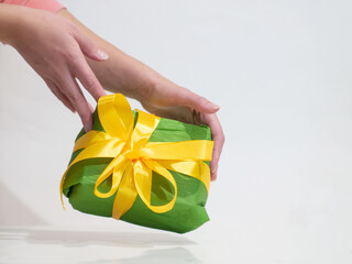 woman giving a green box with yellow bow as a gift