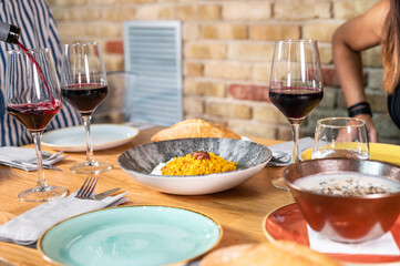Group of people friends or family caucasian celebrate together and enjoy a table full of fresh and coloured healthy food. High quality photo.