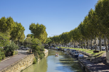 Fototapeta na wymiar Canal de la Robine passes through the city of Narbonne; it connects the Aude and the Mediterranean Sea in the Aude department. Narbonne, Languedoc-Roussillon, France.
