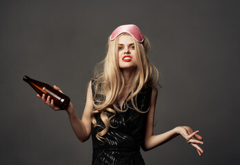 Beautiful blonde with a bottle of beer in her hand and a pink mask on her head