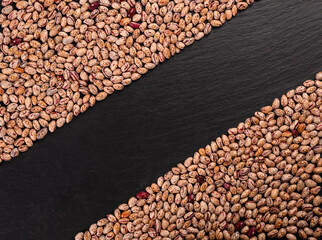 Coloren beans on black stone background.