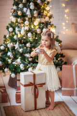 child girl in the new year's interior at the Christmas tree, playing, waiting for the new year, gifts, holiday, happiness, lights, garlands