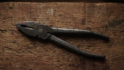Obraz premium Old metal pliers on an old wooden Board
