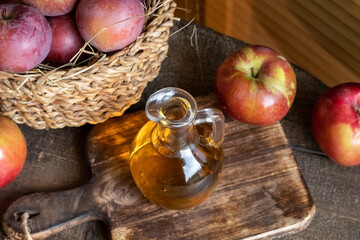 A bottle of apple cider vinegar with fresh apples