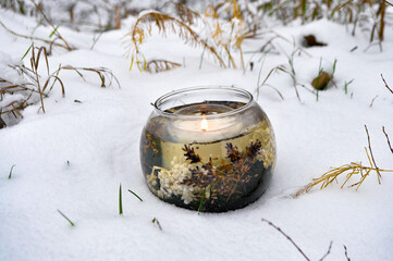 burning candle in the snow