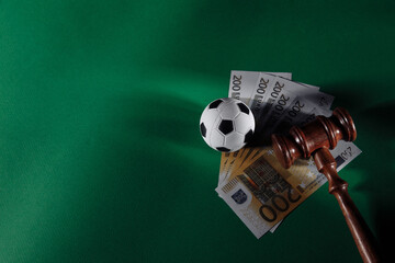 Soccer ball and judge gavel on green background. Corruption in sports or betting concept. - obrazy, fototapety, plakaty