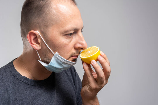 Anosmia or smell blindness, loss of the ability to smell, one of the possible symptoms of covid-19, infectious disease caused by corona virus. Man Trying to Sense Smell of a Lemon
