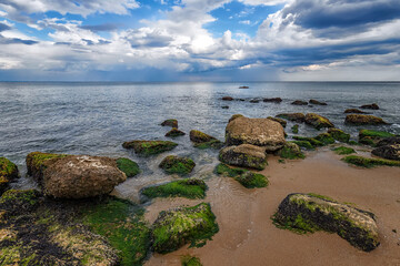 Fototapeta na wymiar Seascape with rocks with moss on the beach