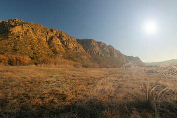 Valle con pasto seco y escarcha, con montaña al fondo. Cañaverosa, Calasparra (Murcia).