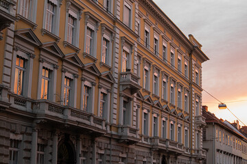 Spiegelungen in Fenstern von älteren Gebäuden bei Sonnenuntergang