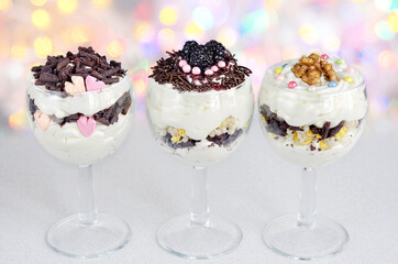 Dessert made of cottage cheese cream and various fillers, in glass glasses and bokeh background. Selective focus