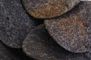 Black potato chips texture and background. Close up