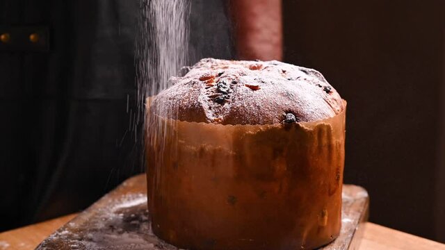 Panettone of Milan. Traditional Italian pastries for Christmas with dried fruits and almonds. Sweet festive bread sprinkled with icing sugar. High quality 4k footage