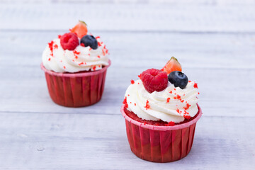 Delicious  cupcakes  with fresh berries( raspberries, strawberries,  blueberry) .Dessert for lovers .
