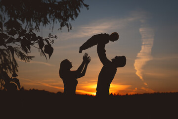 Silhouette einer Familie im Feld bei Sonnenuntergang 