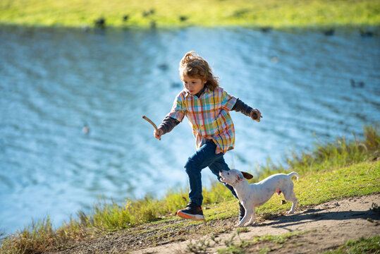 Cute child running with a puppy dog, outdoor summer. - Powered by Adobe