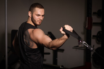 Sporty sexy men with great abdominal muscles in black sportswear working out in the gym.