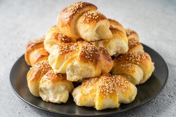 Close up on homemade cheese croissants in ceramic black plate on the marble table - homemade snack for breakfast - organic healthy traditional serbian food