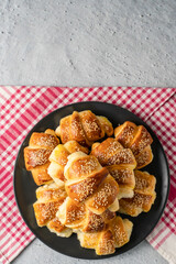 Close up on homemade cheese croissants in ceramic black plate on the marble table - homemade snack for breakfast - organic healthy traditional serbian food top view copy space