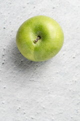 One granny smith green apple on marble bright table with copy space