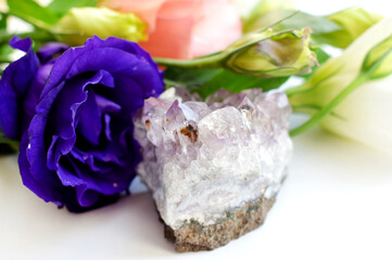 Beautiful purple eustoma (lisianthus) flowers in full bloom with green leaves and amethyst druses.