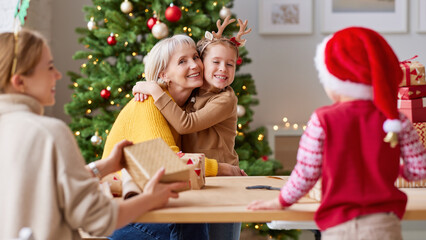 Cheerful relatives wrapping gifts together for Christmas .