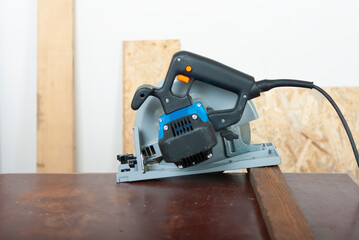 Electric hand tool circular saw on desk, on background oriented strand board