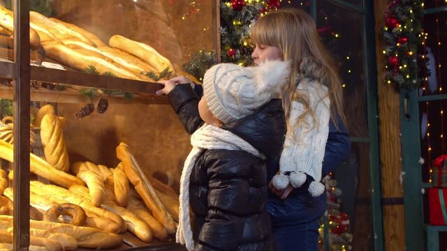 Children choosing bread in bakery in evening