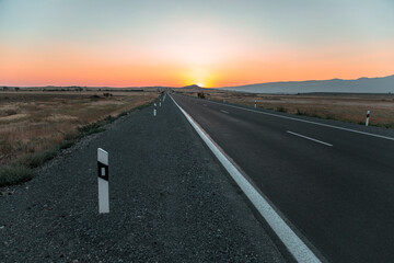 asphalt road with sunset